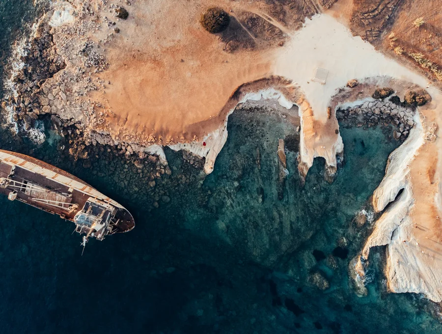 A boat beside a dramatic rocky Mediterranean cove